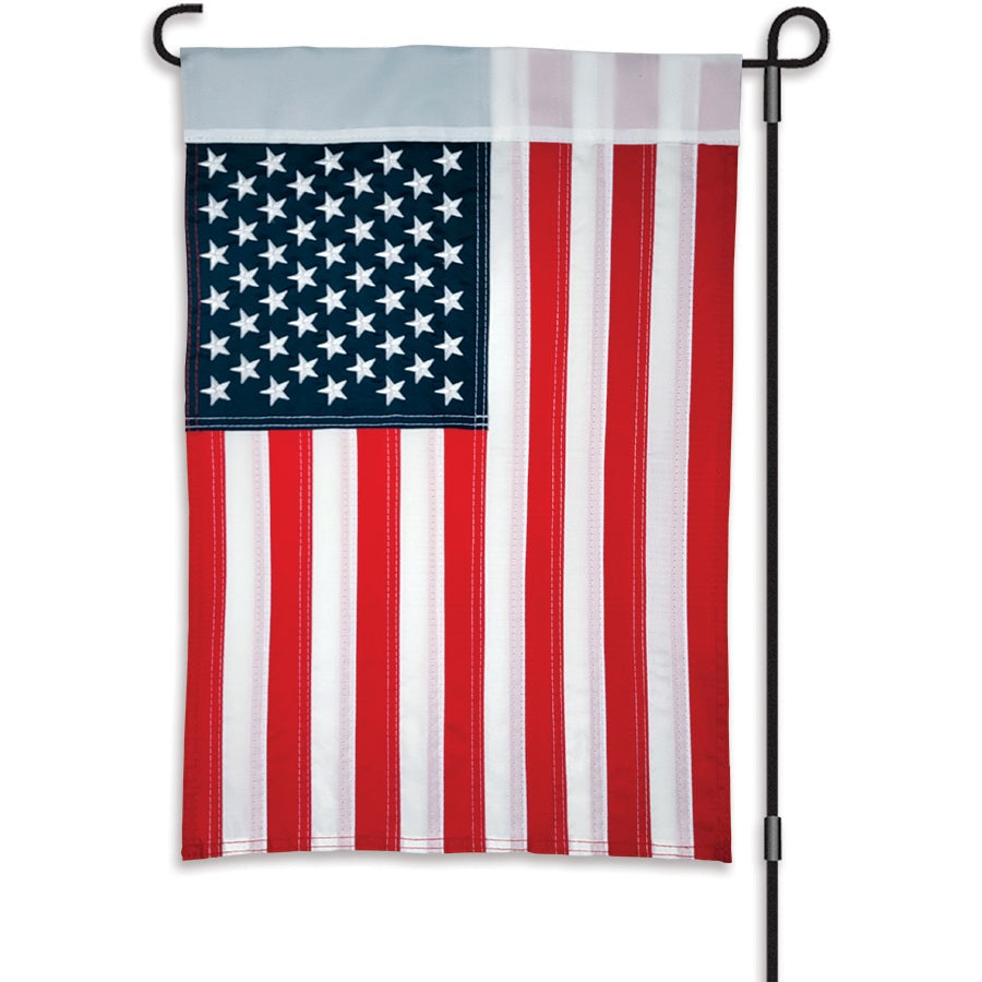 12 in. Embroidered Applique Flag showcasing embroidered stars and appliqued stripes, prominently displayed in a garden setting.