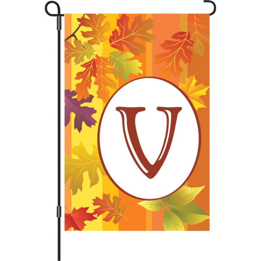 12 in. Fall Monogram Flag - V featuring a vibrant monogram design displayed in a garden setting, reflecting the beauty of autumn.
