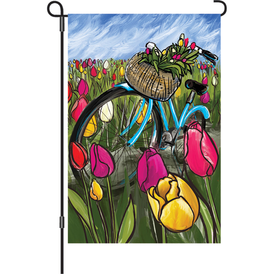 12 in. illuminated garden flag featuring a bike surrounded by colorful tulips, displayed in an outdoor setting during spring.