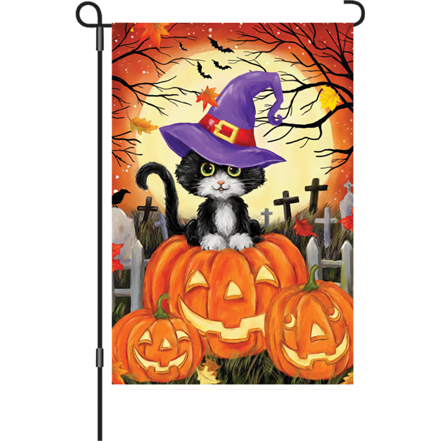 Illuminated 12 in. garden flag featuring a cute black cat design for Halloween, displayed in an outdoor setting.