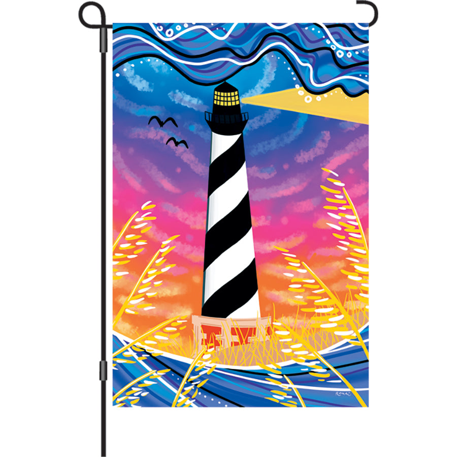 12 in. Flag - Hatteras Sunset design displaying vibrant sunset colors on a garden flag stand in a beautifully landscaped yard.