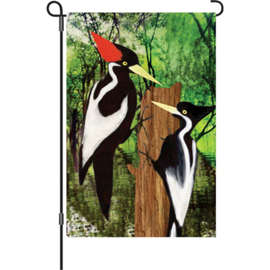 12 in. Flag - Ivory Woodpecker design displayed outdoors, featuring vibrant colors and seasonal autumn themes in a garden setting.