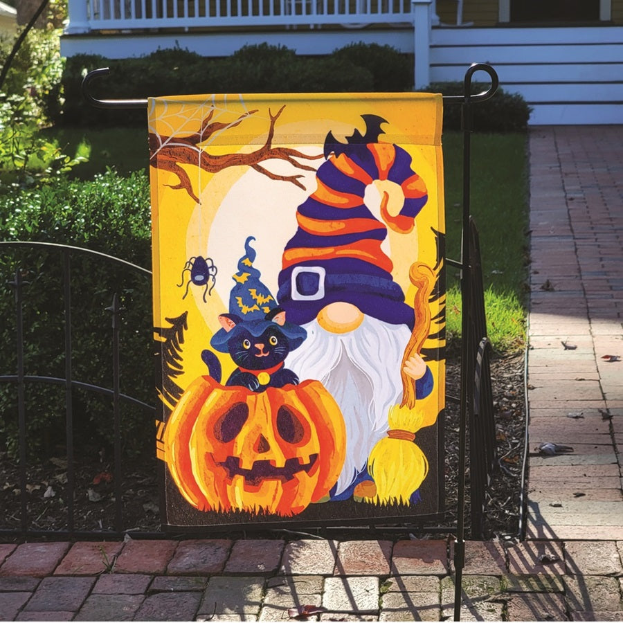 12 in. garden flag depicting a cheerful Halloween gnome with a pumpkin, illuminated for night display in a festive outdoor setting.