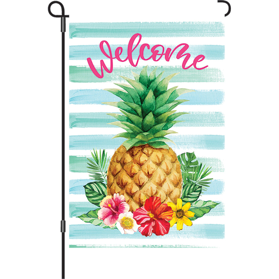 12 in. Hibiscus Pineapple garden flag featuring vibrant floral and pineapple design, displayed on an outdoor flag stand in a sunny garden setting.