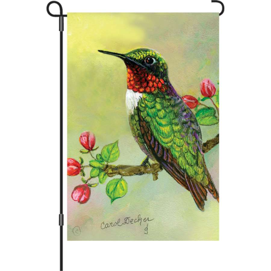 12 in. Hummingbird and Apple Buds garden flag displayed in a garden setting, showcasing intricate design of a hummingbird and apple blossoms.