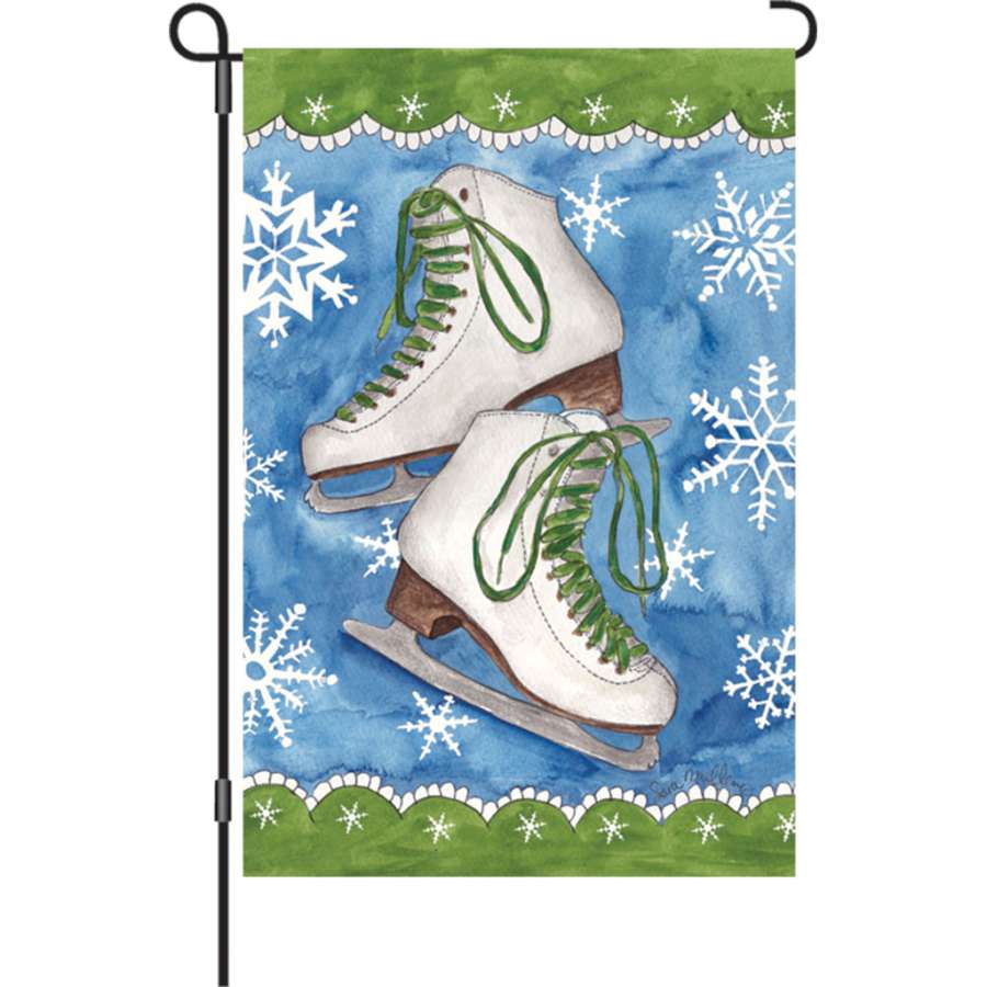 Illuminated 12 in. Ice Skates & Snow garden flag showcasing vibrant ice skate graphics against a snowy background in an outdoor setting.
