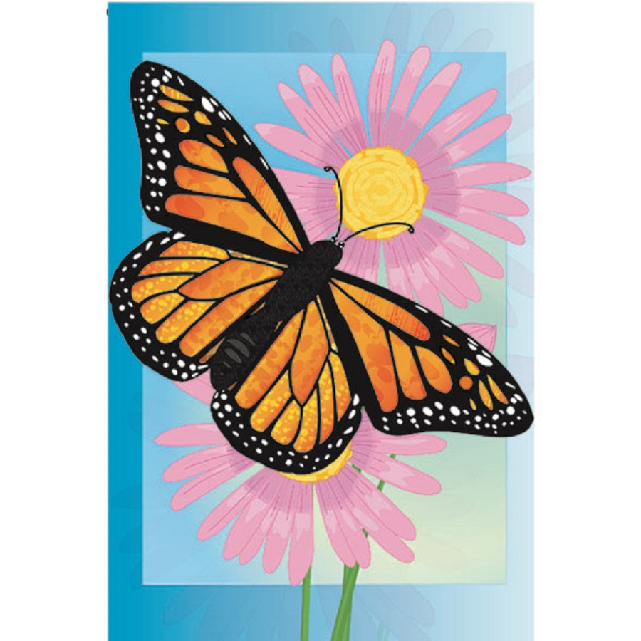 12 in. Merry Monarch garden flag displaying a colorful butterfly and floral design, showcased in an outdoor garden setting with green plants.