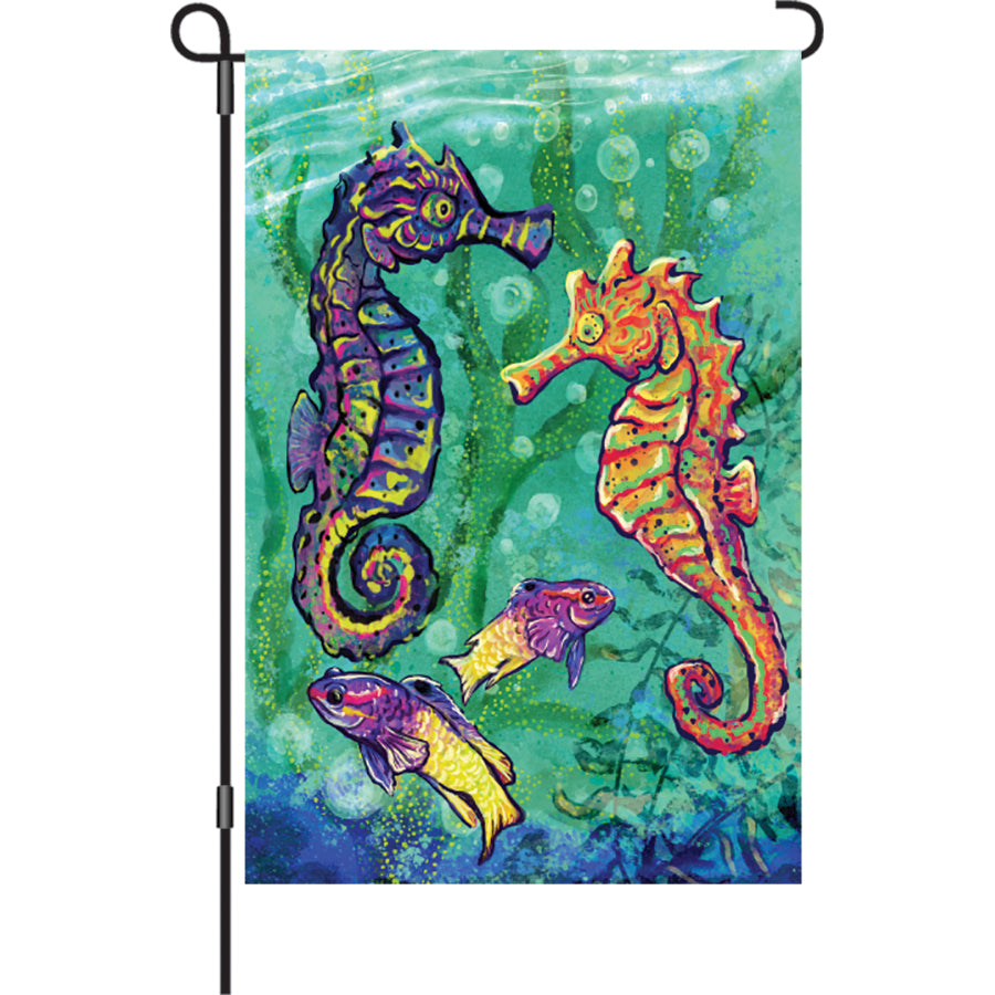 12 in. Seahorses illuminated garden flag featuring colorful seahorse designs, displayed outdoors in a garden setting.