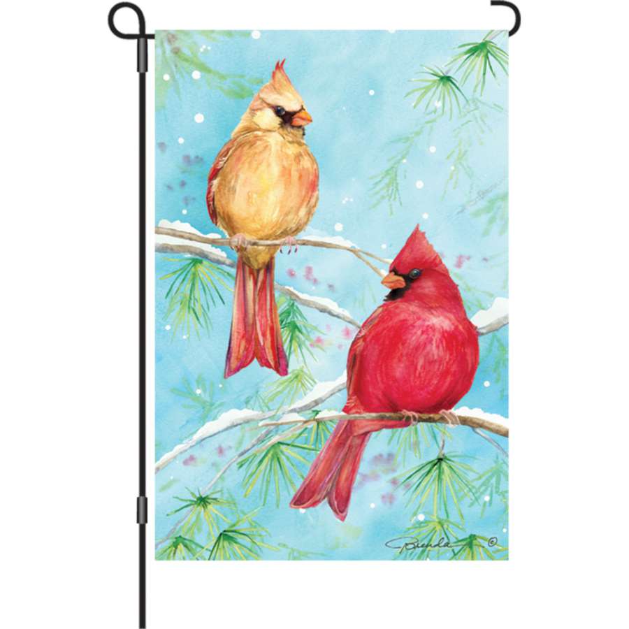 12 in. Winter Cardinals illuminated garden flag featuring vibrant red cardinals on a snowy backdrop displayed in a garden setting.