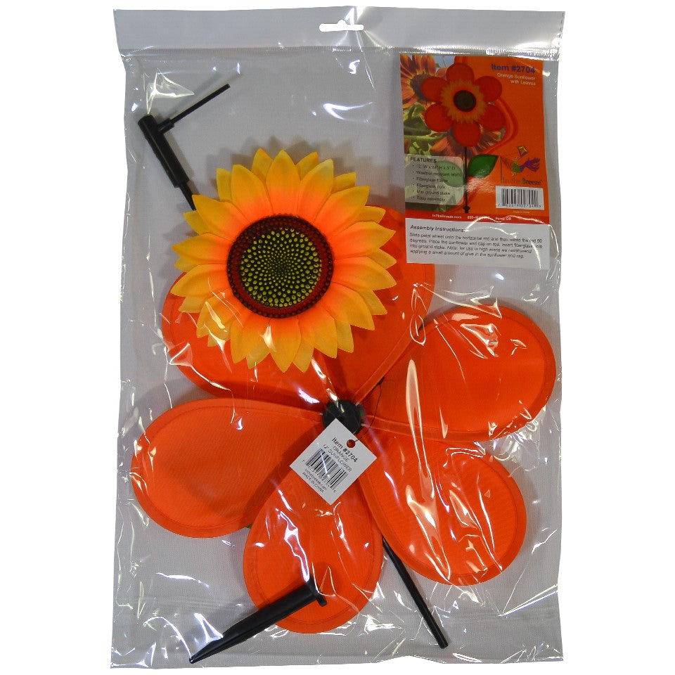 12-inch orange sunflower spinner with bright petals and green leaves, spinning on a sturdy fiberglass pole in a garden setting.