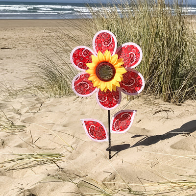 12-inch Paisley Sunflower Spinner with six colorful petals and detailed sunflower center, spinning gently in an outdoor garden setting.