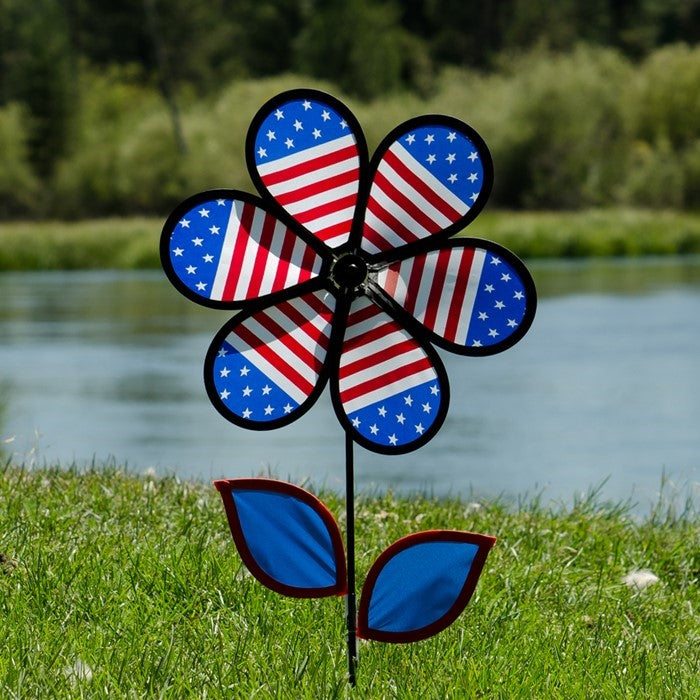 12-inch Patriotic Flower Spinner with stars and stripes petals, colorful leaves on a fiberglass stem, elegantly spinning in the breeze.