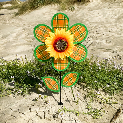 12 inches Plaid Sunflower Spinner with orange and green plaid petals rotating on a 17-inch fiberglass pole in a garden setting.