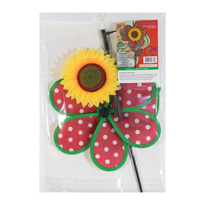 Colorful 12" Polka Dot Sunflower Spinner featuring red and white polka dots, with matching leaves and a sturdy fiberglass pole, displayed outdoors in a garden setting.