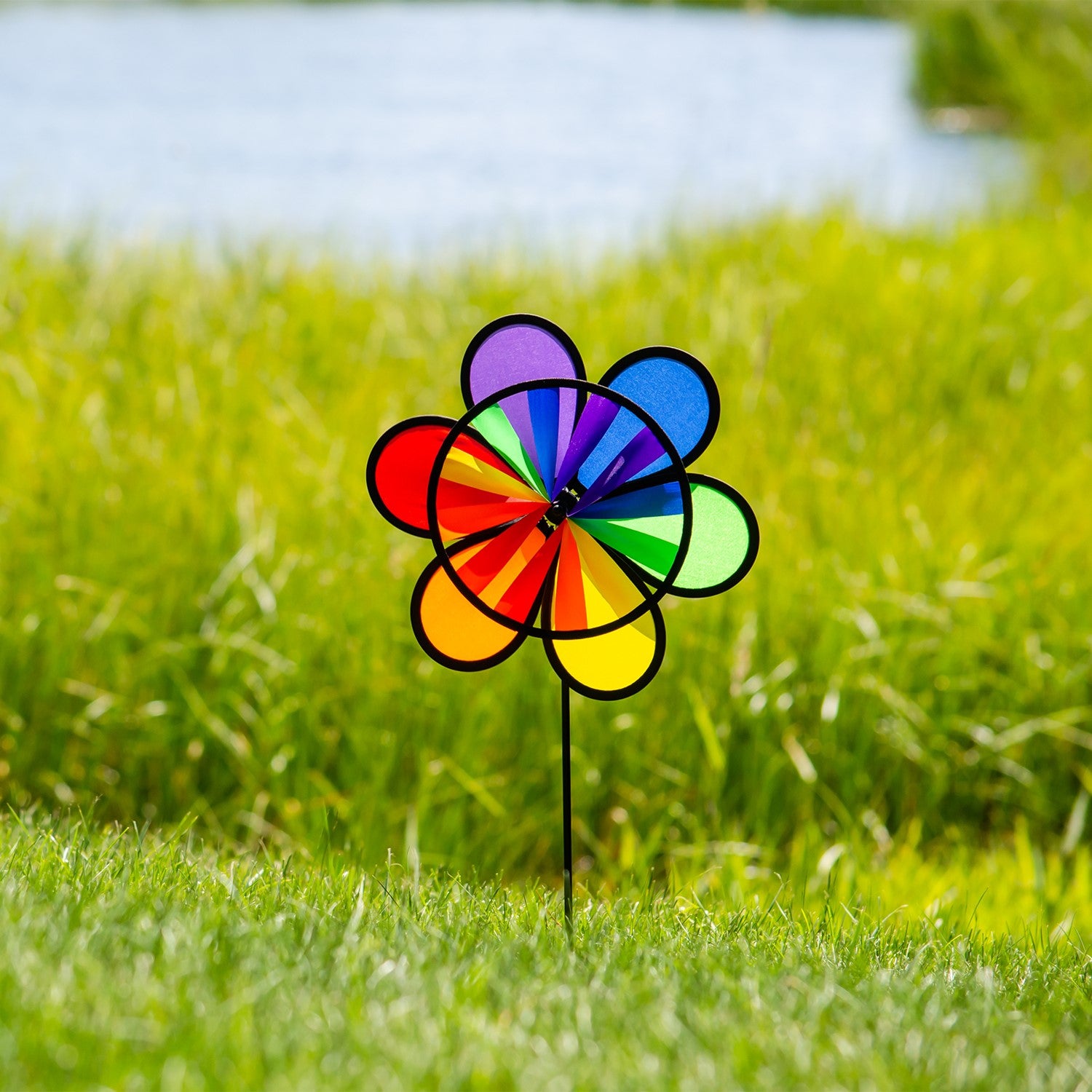 12-inch Rainbow Double Flower Wheel Combo wind spinner with vibrant colors, spinning gracefully in an outdoor garden setting.