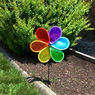 12-inch Rainbow Glitter Flower Spinner featuring colorful petals and a fiberglass pole, spinning effortlessly in a sunny garden setting.