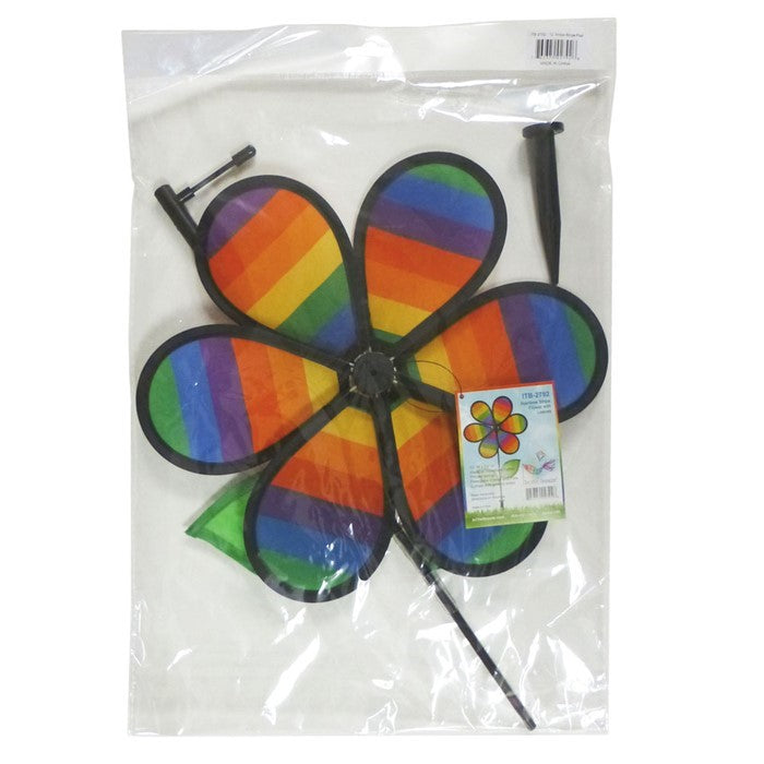 12-inch Rainbow Stripe Flower Spinner with vibrant petals and two leaves attached to a fiberglass pole, spinning in a garden setting.