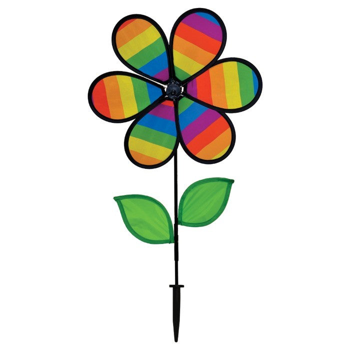 12-inch Rainbow Stripe Flower Spinner with vibrant petals and two leaves attached to a fiberglass pole, spinning in a garden setting.