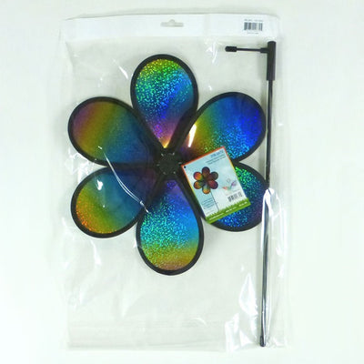12' Rainbow Whirl Flower Spinner with dazzling multi-colored petals spinning on a fiberglass pole in a garden setting.