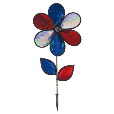 12-inch red, white, and blue sparkle flower spinner rotating in a garden, showcasing its Mylar petals and sturdy fiberglass pole.