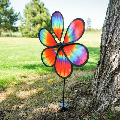 Colorful 12\" Tie Dye Daze Flower Spinner displaying vibrant tie-dye colors, spinning in a sunny garden setting, showcasing its whimsical design.