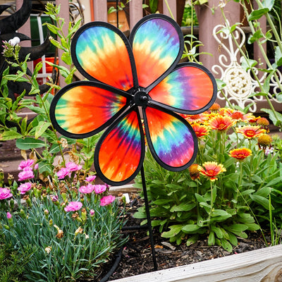 Colorful 12\" Tie Dye Daze Flower Spinner displaying vibrant tie-dye colors, spinning in a sunny garden setting, showcasing its whimsical design.