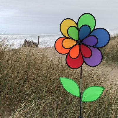 12-Petal Flower with Leaves Double Wheel Spinner featuring rainbow petals and leaves, displayed in a garden setting spinning gently in the breeze.