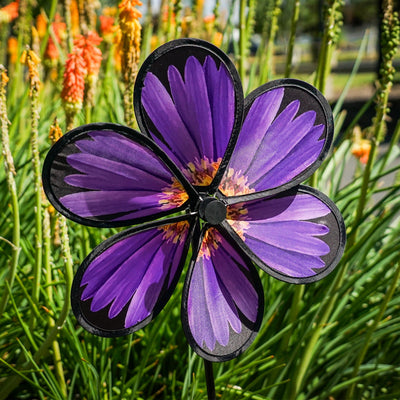 13.5-inch Aster Spinner with vibrant petals and green leaves, showcasing realistic flower design in an outdoor garden setting.