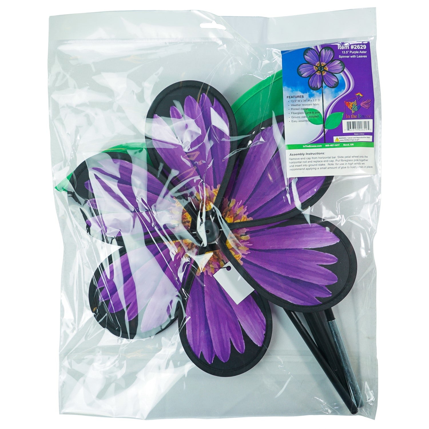 13.5-inch Aster Spinner with vibrant petals and green leaves, showcasing realistic flower design in an outdoor garden setting.