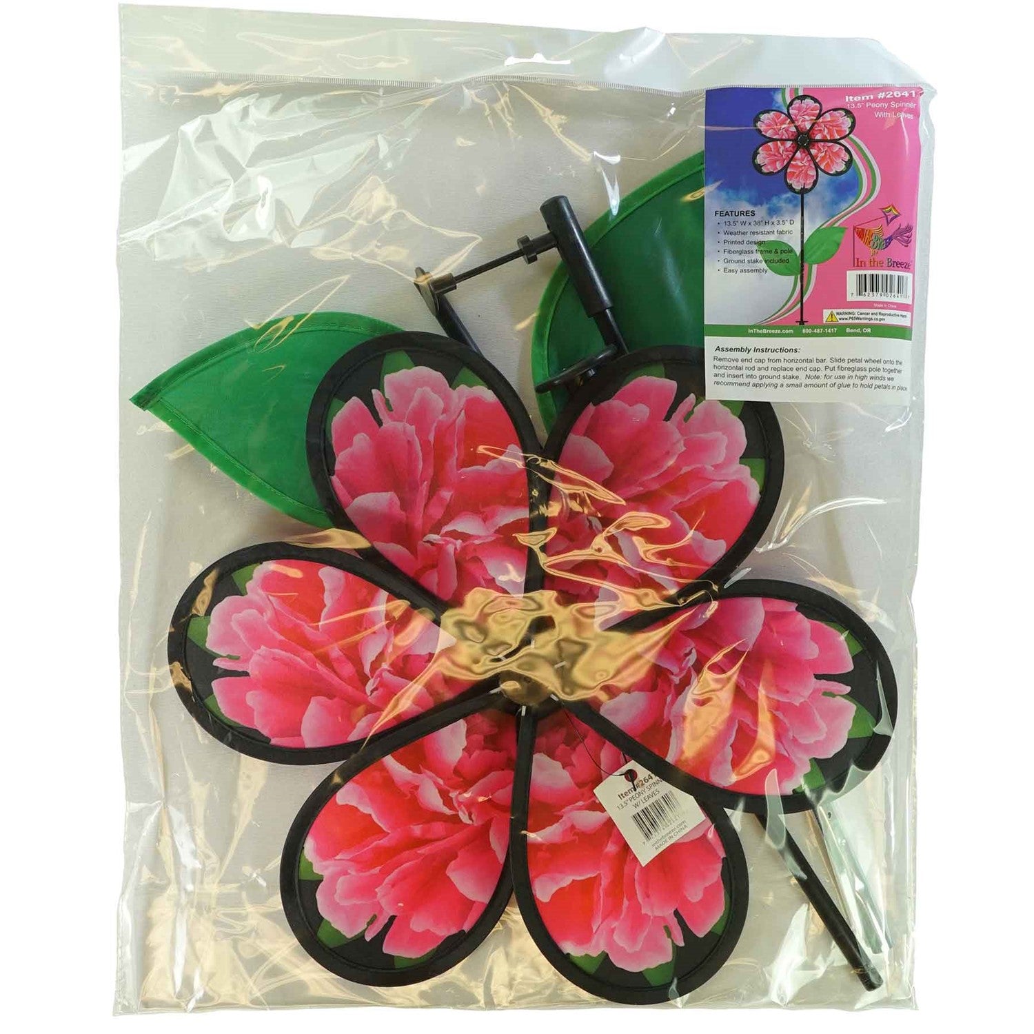 13.5 inch Peony Spinner with realistic printed petals and green leaves spinning in a charming outdoor garden setting.