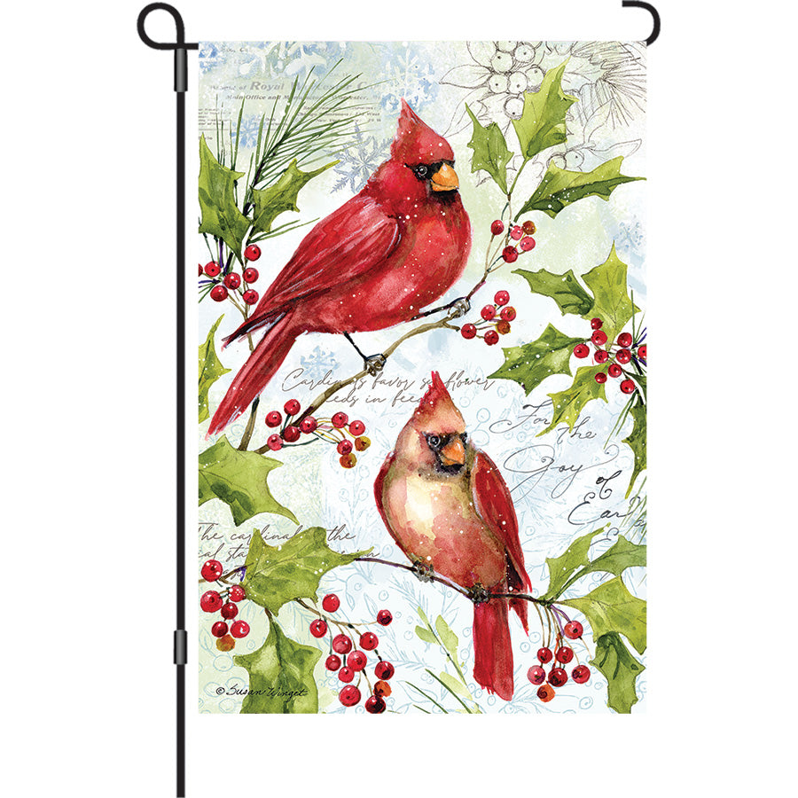 Holly Cardinals Elite Oversized Garden Flag in vibrant colors, designed by Susan Winget, displayed on a garden flag pole in a winter setting.