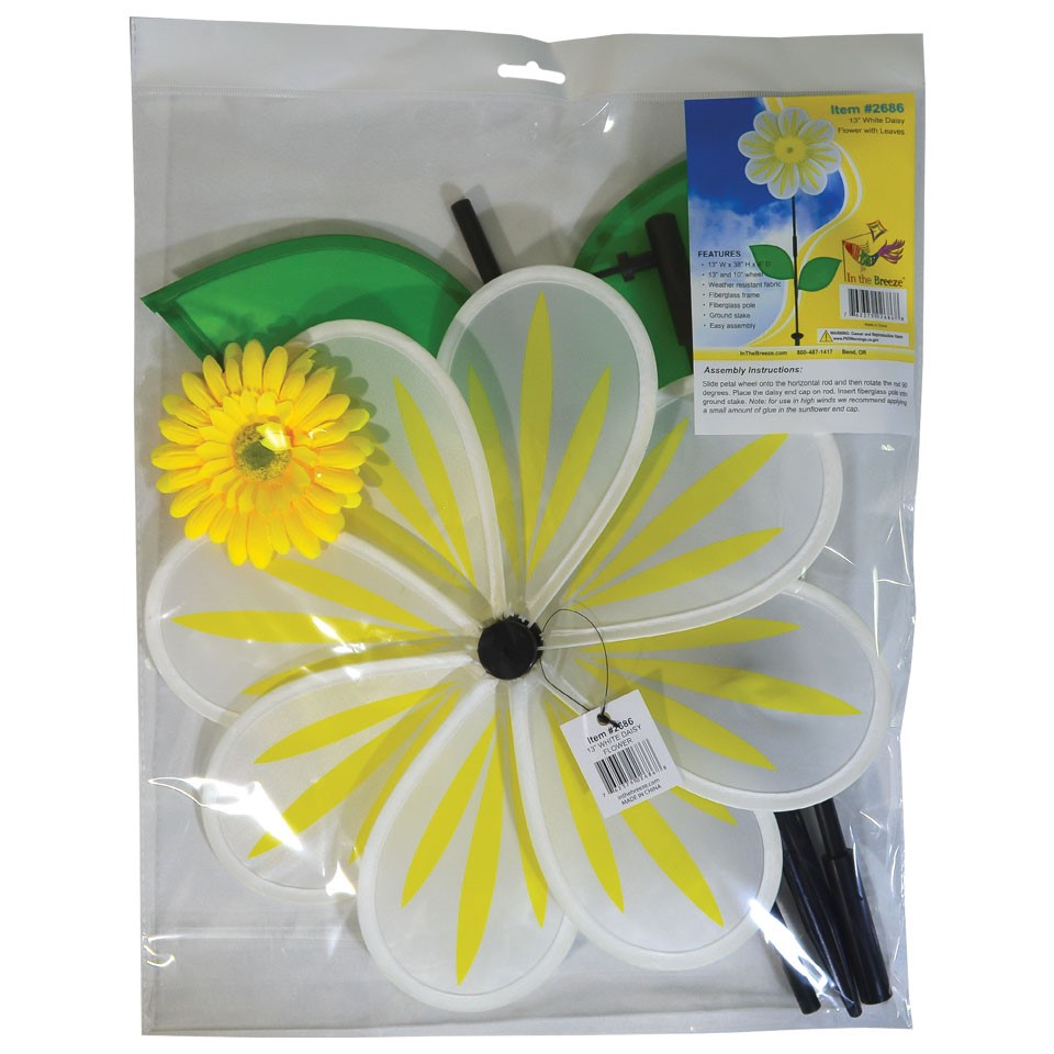 A 13-inch White Daisy Flower Spinner spinning in a garden, featuring an 8-petal design with a white floral motif against a natural backdrop.