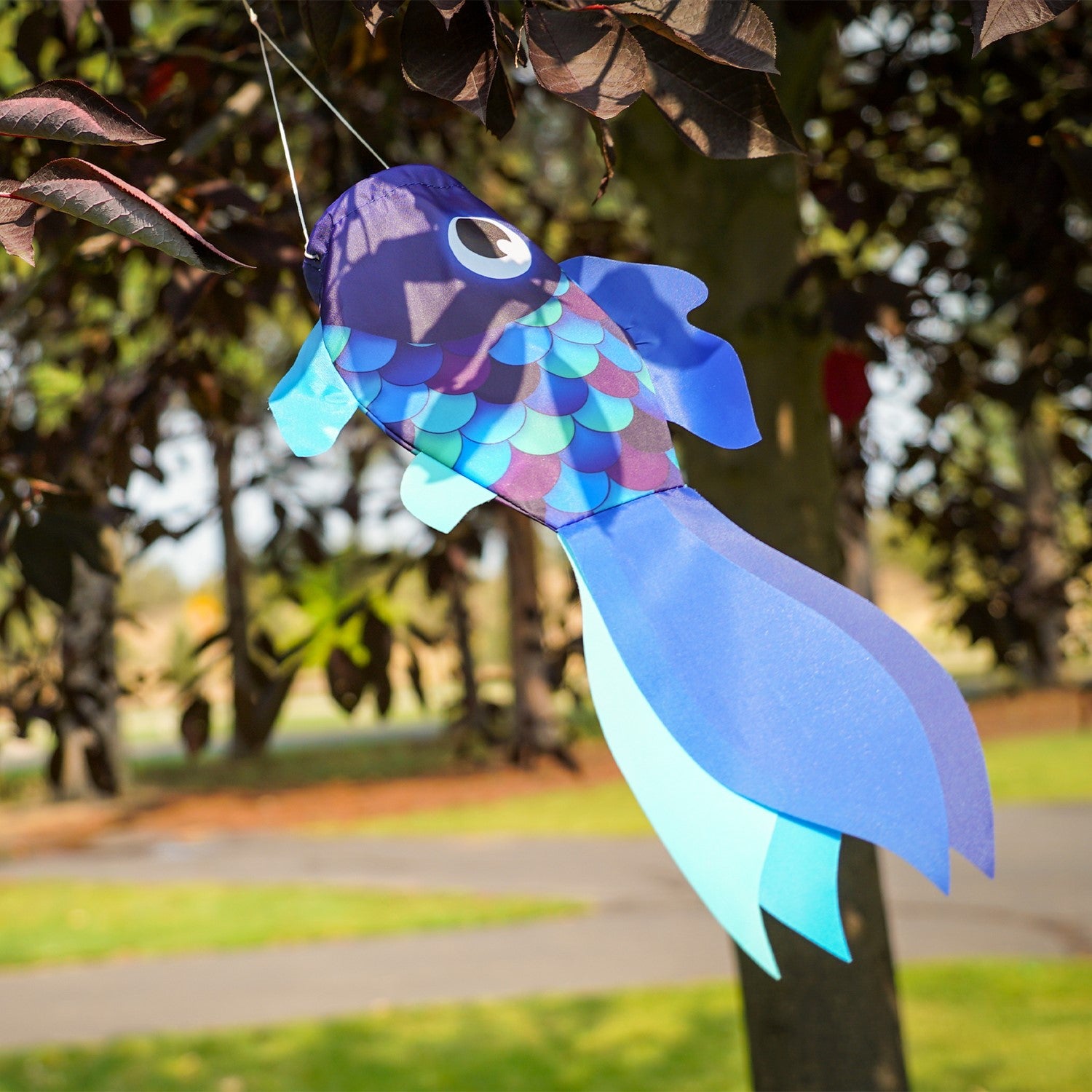 15-inch Cool Damsel Fish windsock featuring vibrant colors, gracefully fluttering in the breeze on a garden pole.