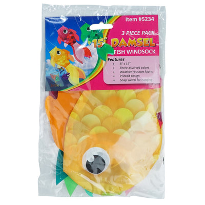 Three colorful Damsel Fish windsocks in pink, yellow, and green, hanging in a garden, gently moving with the breeze under a sunny sky.