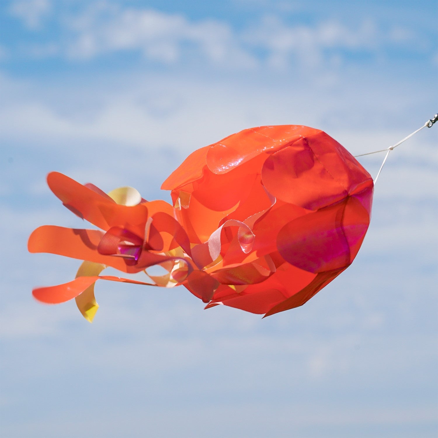 15-inch Orange Iridescent Jellyfish 3D Windsock swaying in the breeze, showcasing vivid colors and realistic jellyfish design.