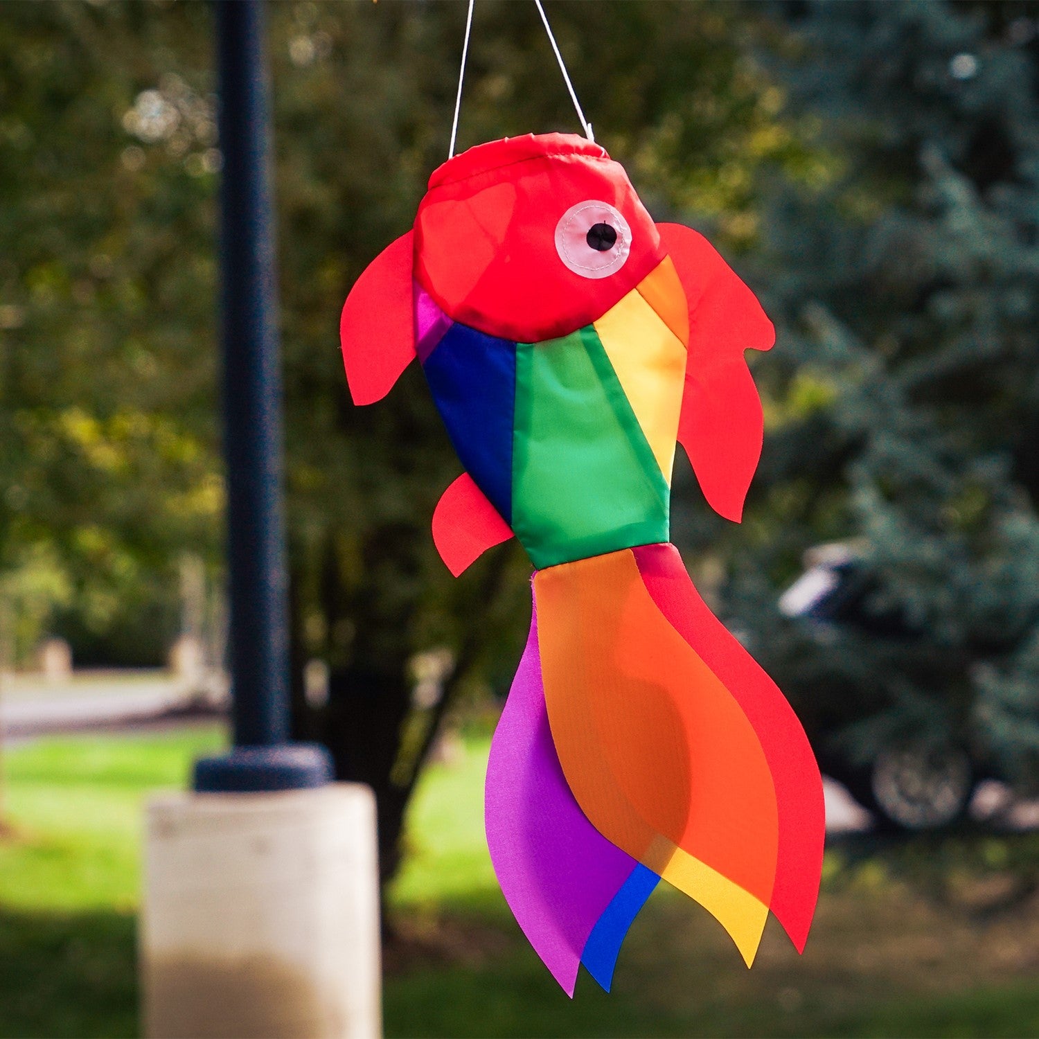 15-inch Rainbow Damsel Fish windsock displaying colorful rainbow applique design fluttering elegantly in the wind against a blue sky.