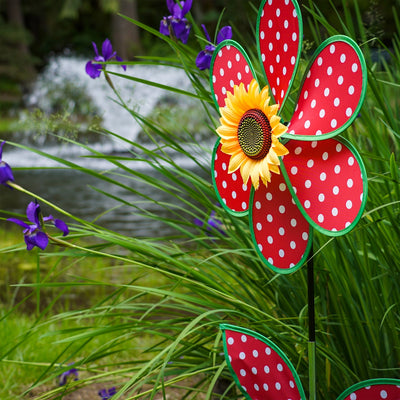 16" Polka Dot Flower with Leaves garden spinner featuring red and white polka dot petals and a sunflower center, displayed outdoors.