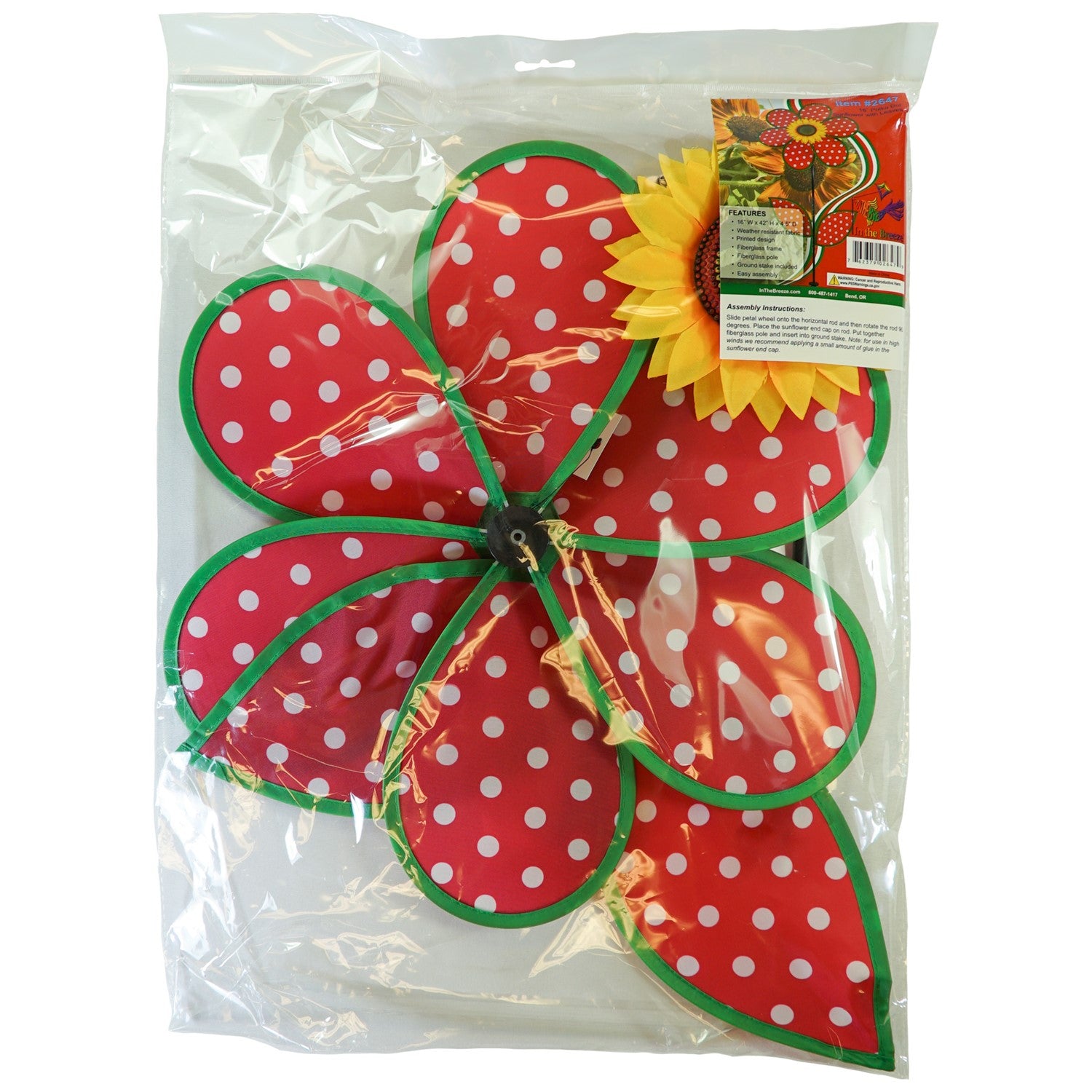 16" Polka Dot Flower with Leaves garden spinner featuring red and white polka dot petals and a sunflower center, displayed outdoors.