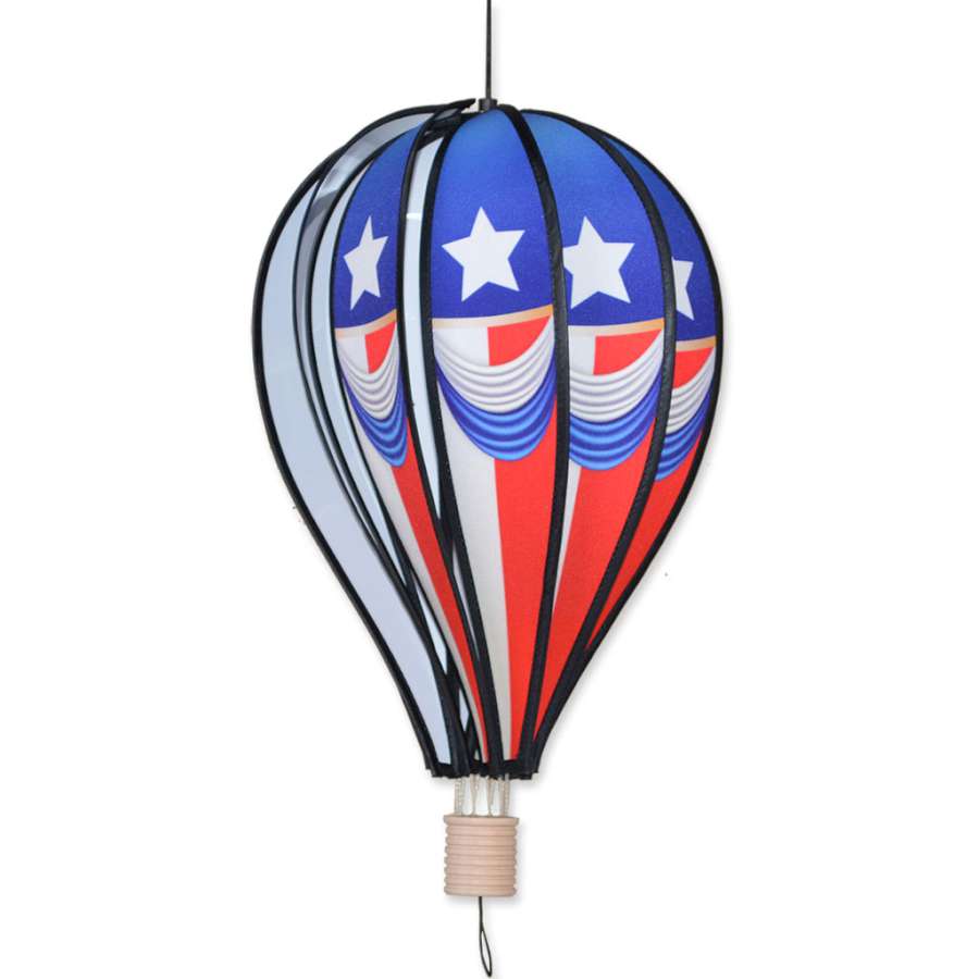 18 in. Hot Air Balloon - Vintage Patriotic spinning gracefully in an outdoor garden, showcasing vibrant red, white, and blue colors.