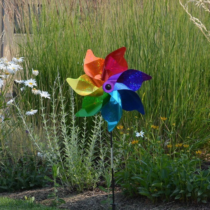 18-inch Rainbow Sparkle Pinwheel Spinner made of Mylar with vibrant colors spinning in the wind on a garden pole.