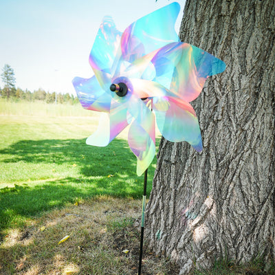 18-inch striped iridescent pinwheel spinner made of durable Mylar, vibrant pastel colors, displayed outdoors in a garden setting.