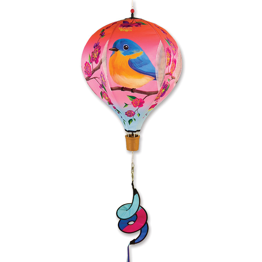 19 in. Pop-Open Hot Air Balloon in vibrant Bluebird and Plum Blossom colors, spinning gracefully in outdoor surroundings against a sunny blue sky.