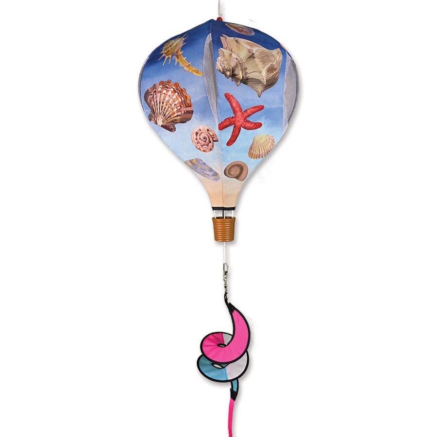 19 in. Pop-Open Hot Air Balloon featuring colorful sea shell design, spinning gently in the outdoor breeze on a sunny day.