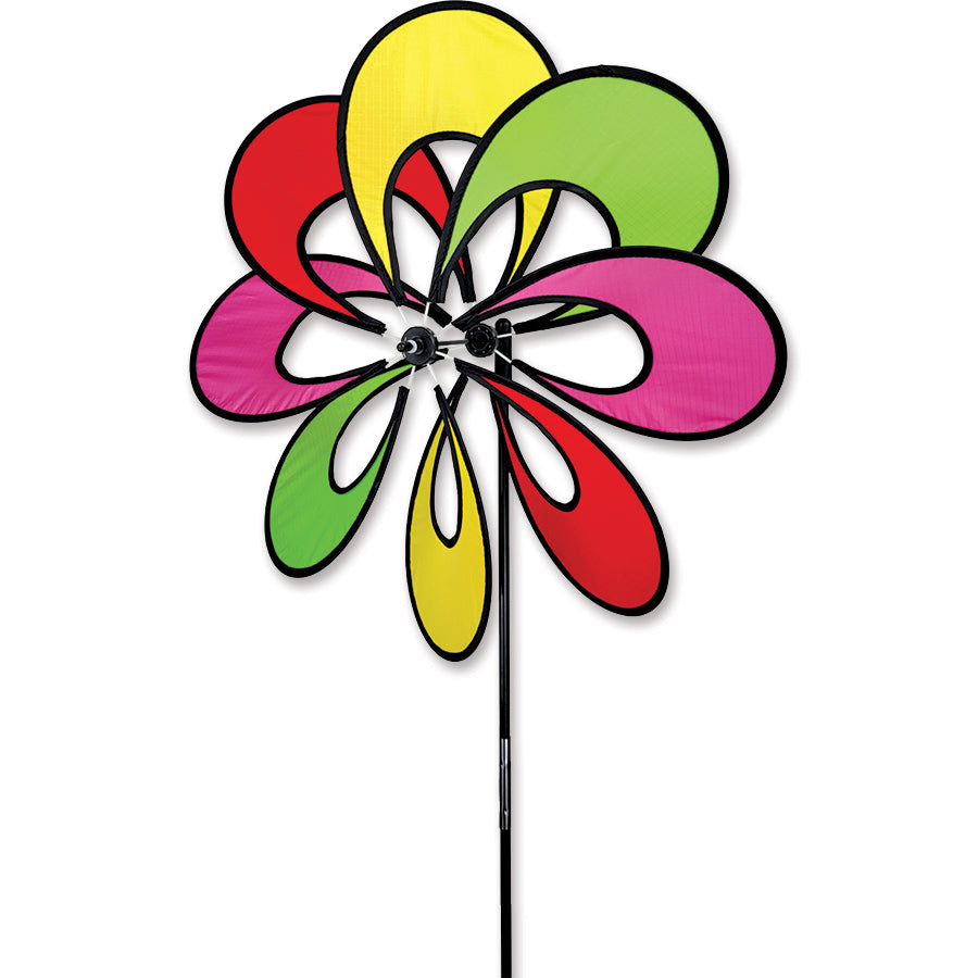 19 in. Single Whirly Spinner with neon petals spinning in the breeze, enhancing the charm of an outdoor garden setting.