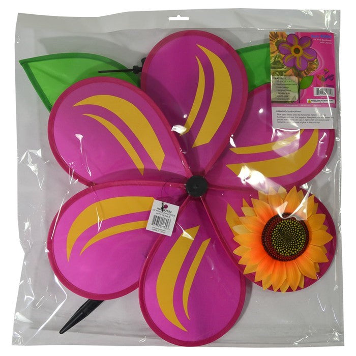 19-inch pink sunflower spinner with six petals, realistic sunflower center, and two green leaves, mounted on a sturdy fiberglass pole in a garden setting.