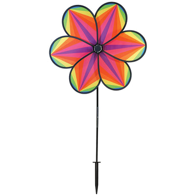 19-inch Rainbow Star Flower Spinner with colorful striped petals spinning in the breeze, displayed in a garden setting.