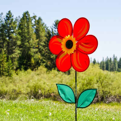 19 inch Red Sunflower Spinner with six bold petals and leaves, rotating on a fiberglass pole in a sunny outdoor garden setting.