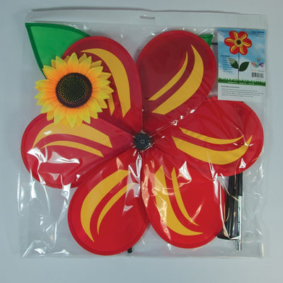19 inch Red Sunflower Spinner with six bold petals and leaves, rotating on a fiberglass pole in a sunny outdoor garden setting.