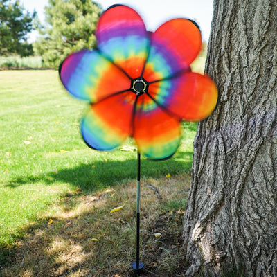 Colorful 19\" Tie Dye Daze Flower Spinner with psychedelic tie-dye design on a garden pole, creating a charming spiral effect in the breeze.