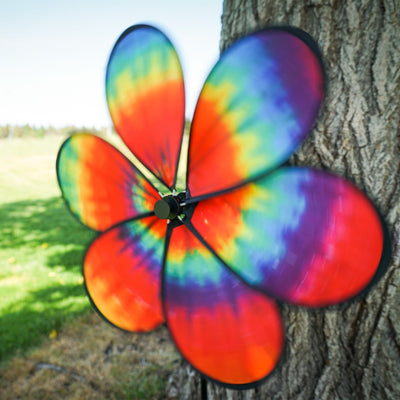 Colorful 19\" Tie Dye Daze Flower Spinner with psychedelic tie-dye design on a garden pole, creating a charming spiral effect in the breeze.